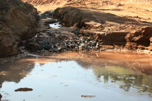 Spring water mixing with sediment flowing through a construction site on the new County Road AAA on August 5, 2014. Photo courtesy of Jeremiah Eagle Eye.